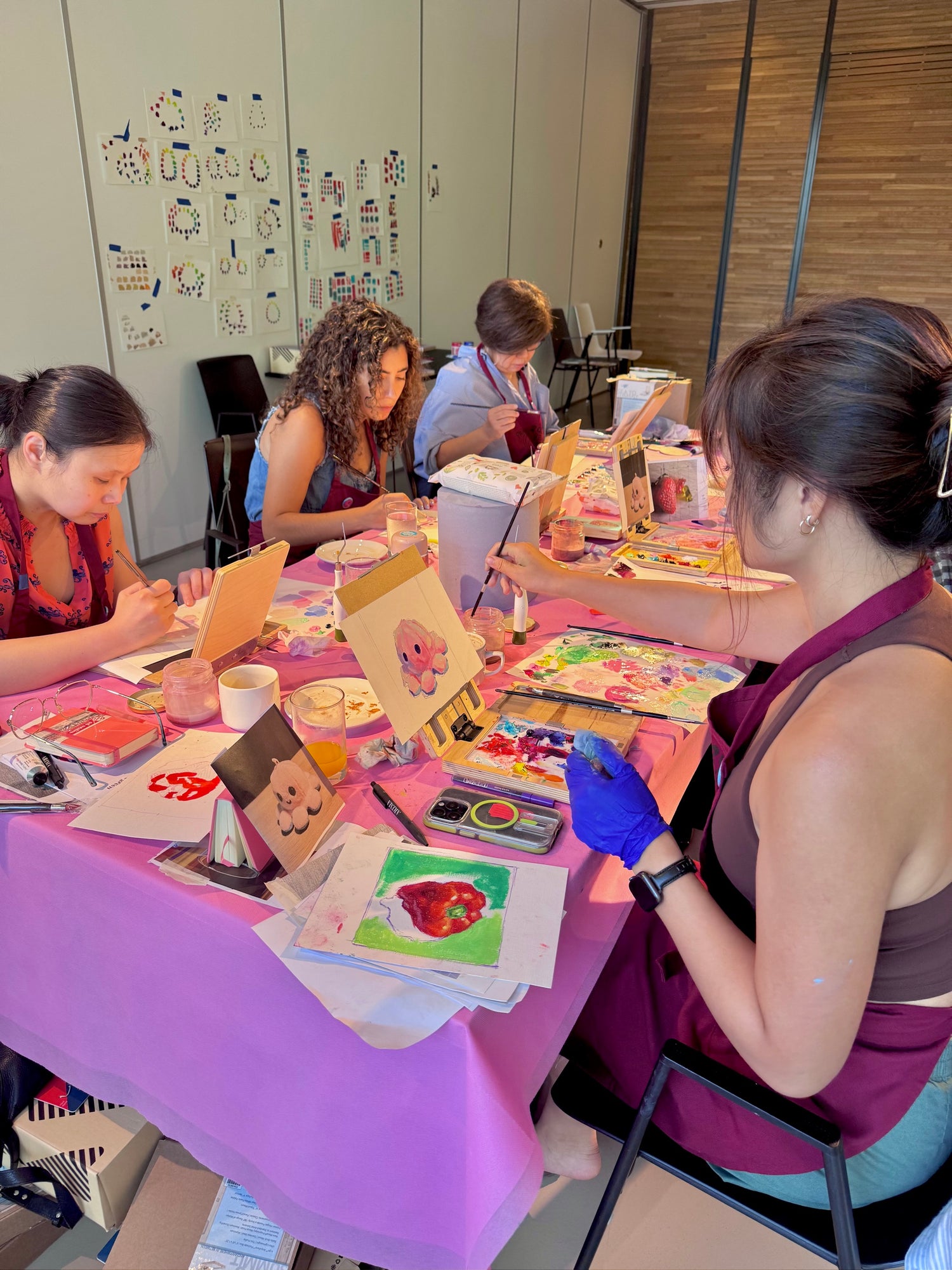 Participants painting colorful artworks during a group workshop at the 2025 art retreat led by Alai.