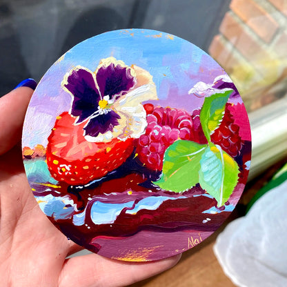 Original oil painting by Alai Ganuza titled "Berries and Flowers". A round composition featuring a strawberry slice, raspberries, and a purple pansy flower resting on a dark glossy sauce, painted on a small 4-inch wood panel.