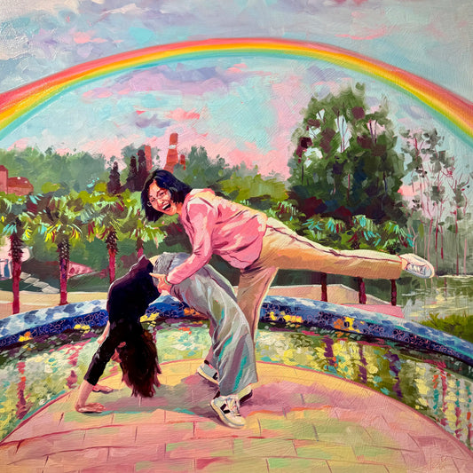 An original 40x40 cm oil painting of a mother and daughter playfully balancing together by a park pond. Set under a bold, vibrant summer rainbow and blue sky with thick impasto texture.