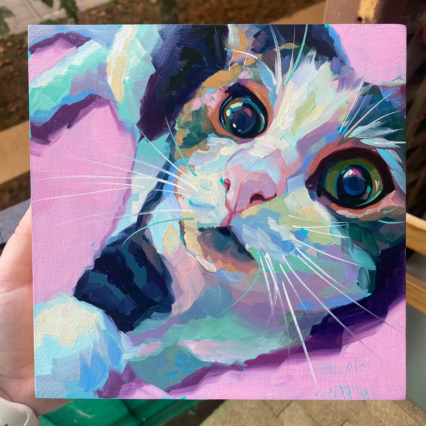 An original 8x8 oil painting of a cat named Fredward looking at the camera from a sideways, upside-down position. Features massive expressive eyes and a textured light pink and lavender background.