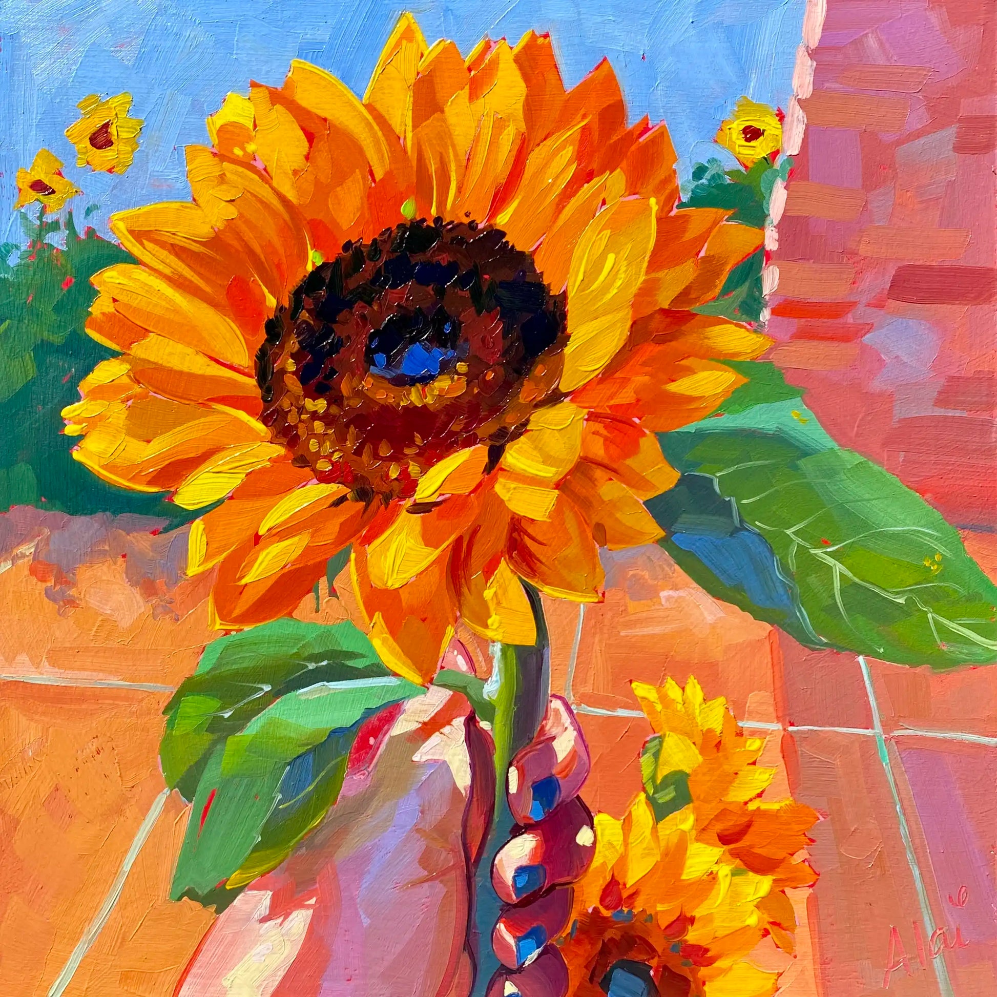 Original oil painting by Alai Ganuza titled "Holding a Sunflower". A hand holding a large, bright orange and yellow sunflower with green leaves against a background of terracotta tiles and blue sky, painted on a square wood panel.