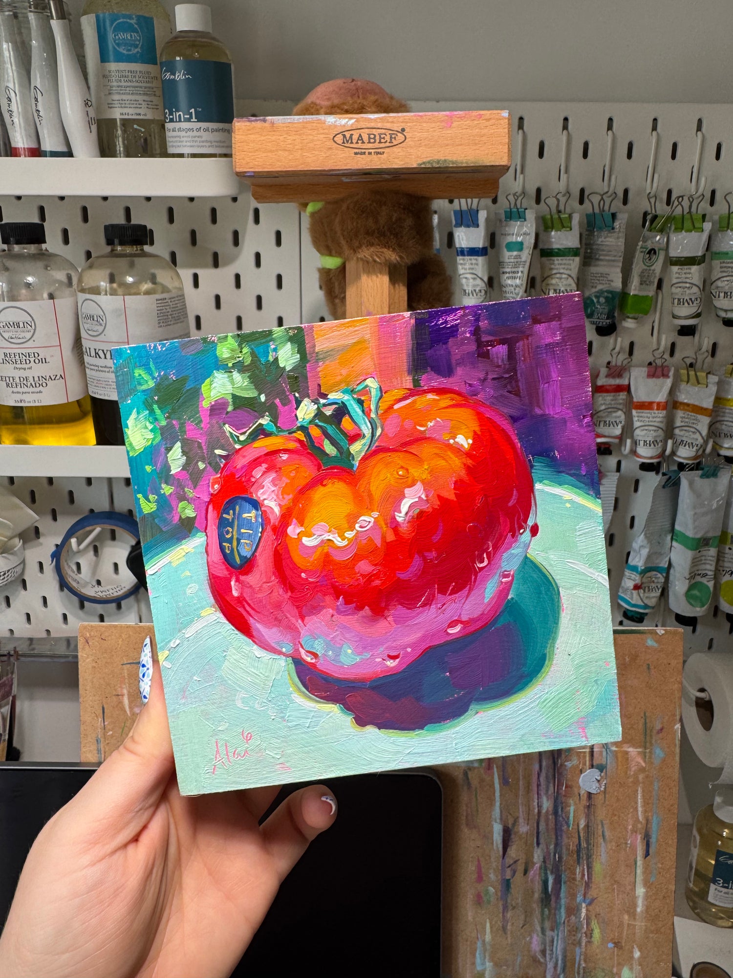 Alai holding her pomodoro painting, high contrast still life