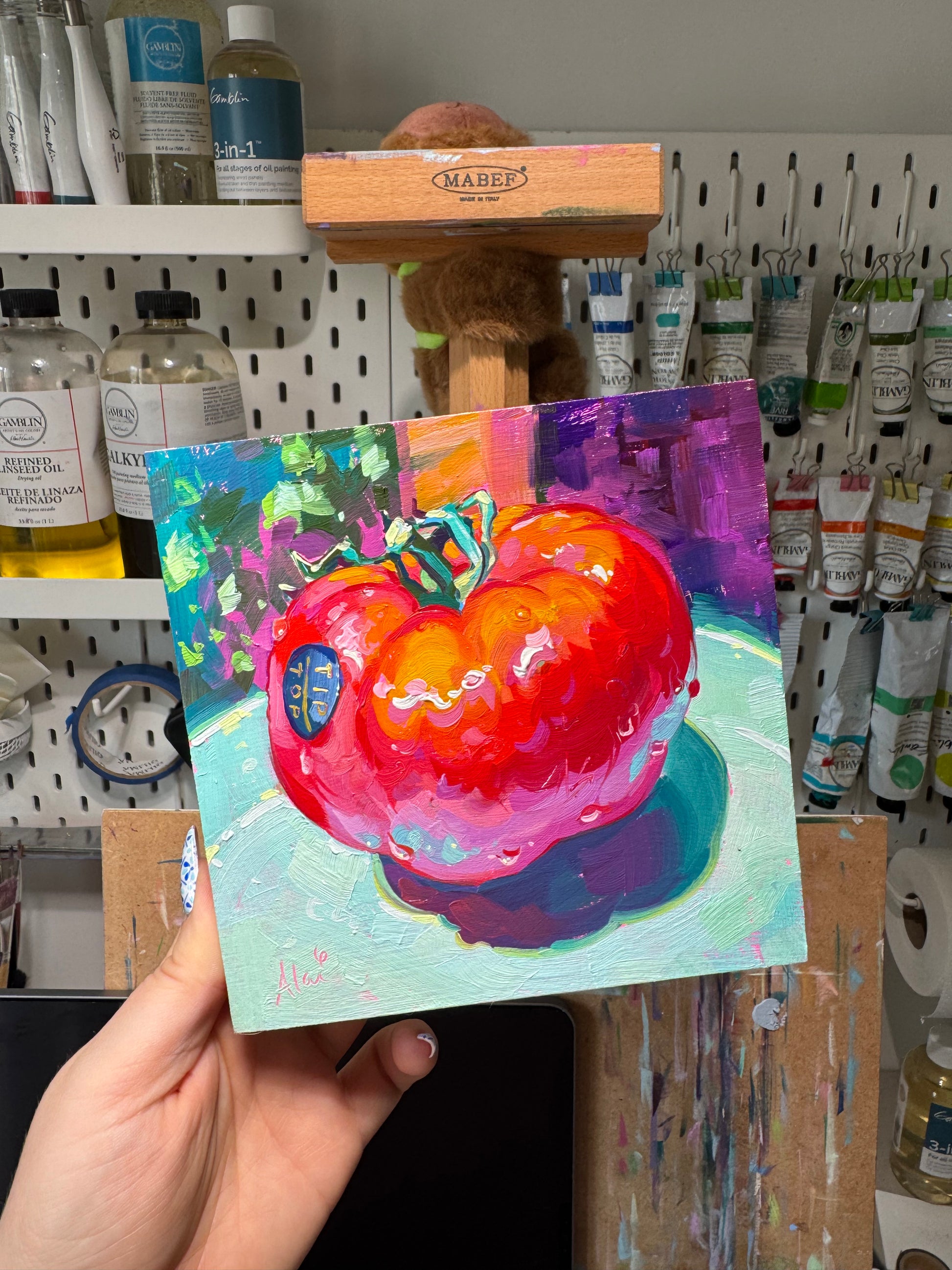 Alai holding her pomodoro painting, high contrast still life