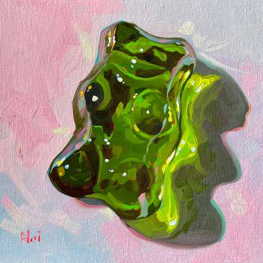 Original oil painting by Alai Ganuza titled "Sweet Life: Green". A large, glossy green gummy bear candy, rendered with translucent textures and bright highlights, on a pastel pink and blue background.