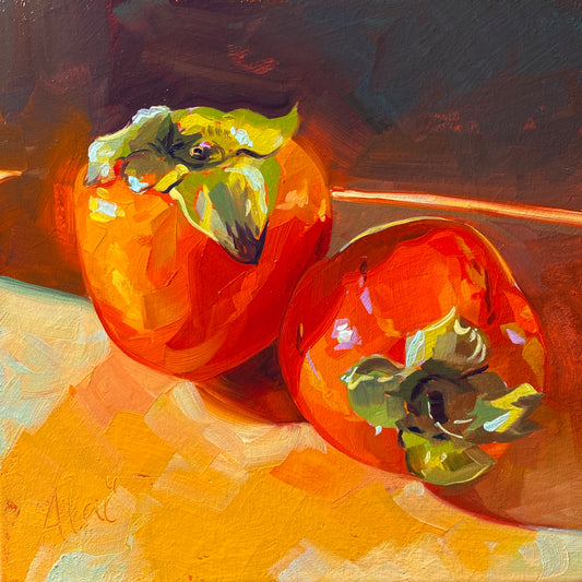 Original oil painting by Alai Ganuza titled "Persimmons (Vibrant)". Two bright orange persimmons with green leafy tops resting on a warm surface, painted with saturated colors on an orange underpainting.