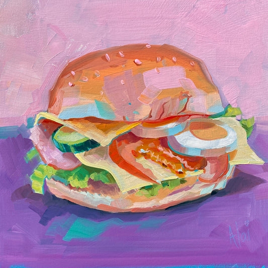 Original oil painting by Alai Ganuza titled "Sandwich". A tall, appetizing sandwich with a sesame bun, cheese, tomato, lettuce, cucumber, and onion, resting on a deep purple surface against a pastel pink background.