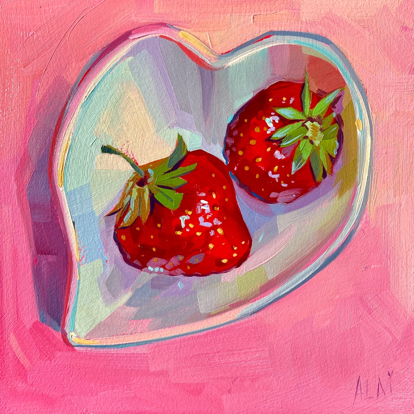 Original oil painting by Alai Ganuza titled "Strawberry Heart Plate". Two bright red strawberries with green stems resting in a clear, heart-shaped glass dish against a textured pink background on a square wood panel. Reference by Marcela Cabrera.
