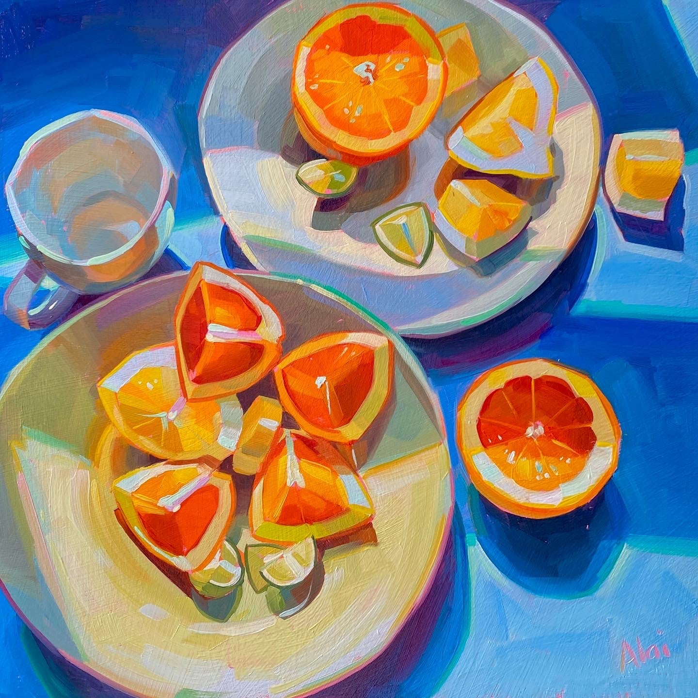Original oil painting by Alai Ganuza titled "Citrus". A top-down view of sliced oranges and limes arranged on two plates and scattered on a vibrant blue table next to a white teacup.