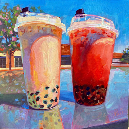 Original oil painting by Alai Ganuza titled "Two Boba Tea Cups". Two plastic cups of bubble tea, one milky beige and one reddish-orange, sitting on a reflective surface outdoors under a blue sky with trees in the background.