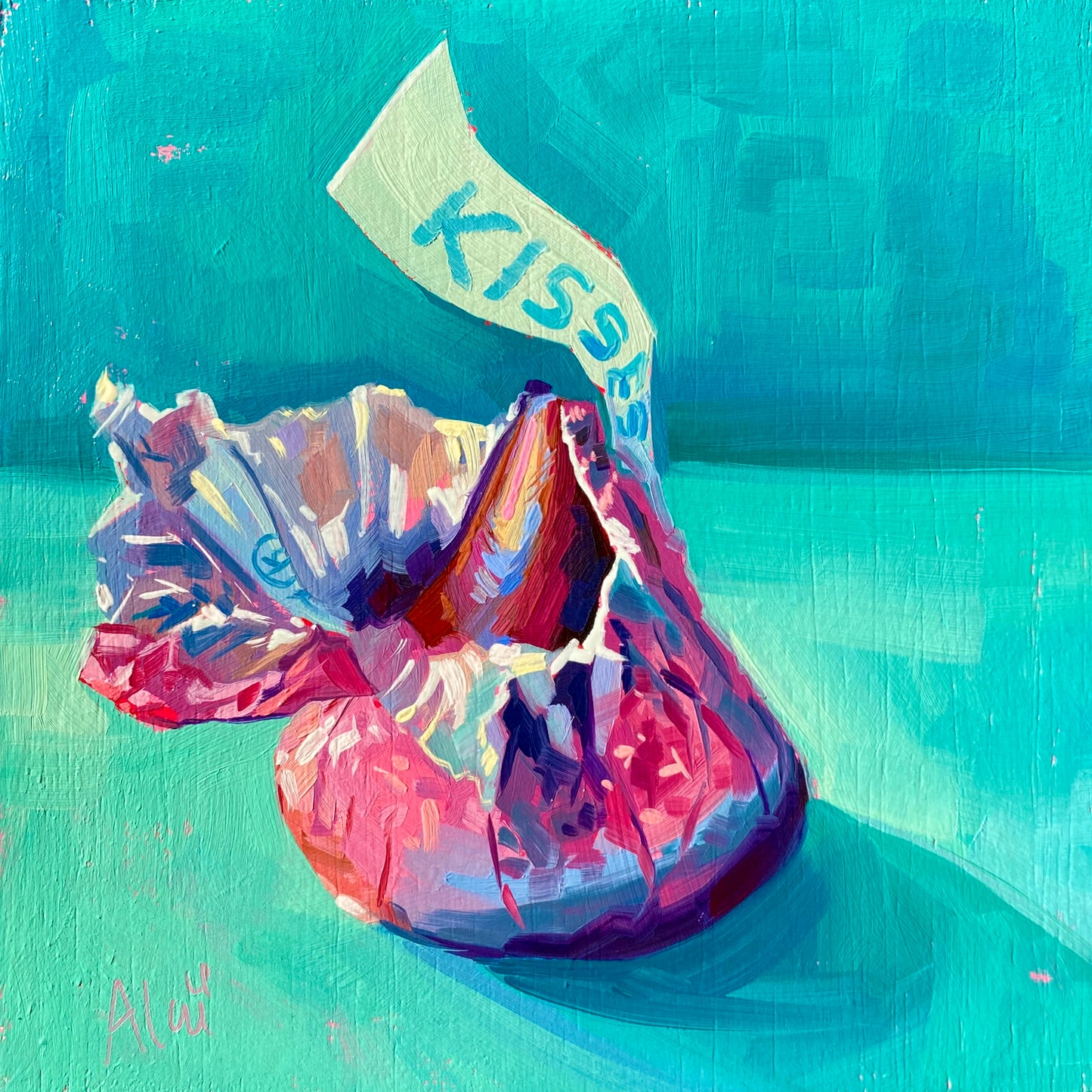 Original oil painting by Alai Ganuza titled "Kisses". A single unwrapped chocolate Kiss sitting next to its crumpled pink and silver foil wrapper with the iconic blue "KISSES" tag, painted on a bright teal background. Reference by Kate Birch.