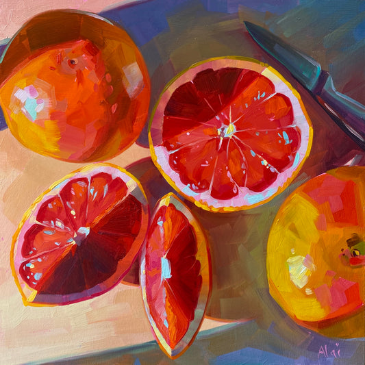 Original oil painting by Alai Ganuza titled "Grapefruits in the Evening". Several sliced ruby red grapefruits and a knife resting on a surface, illuminated by warm, directional evening light casting deep purple shadows.