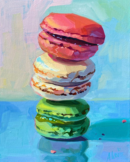 Original oil painting by Alai Ganuza titled "Macaroons". A vertical stack of three colorful macarons—pink, white, and green—rendered in thick impasto against a vibrant blue and lavender background.